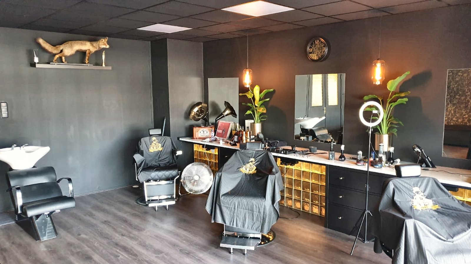Het echte interieur van The Dandy Fox: de grijze werkplekken, spiegels en amberkleurige glasblokken